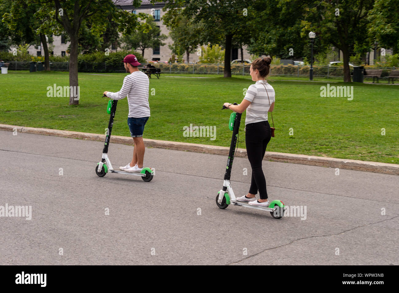 Montreal, CA - 7 Settembre 2019: due persone a cavallo di un lime scooter elettrici Foto Stock