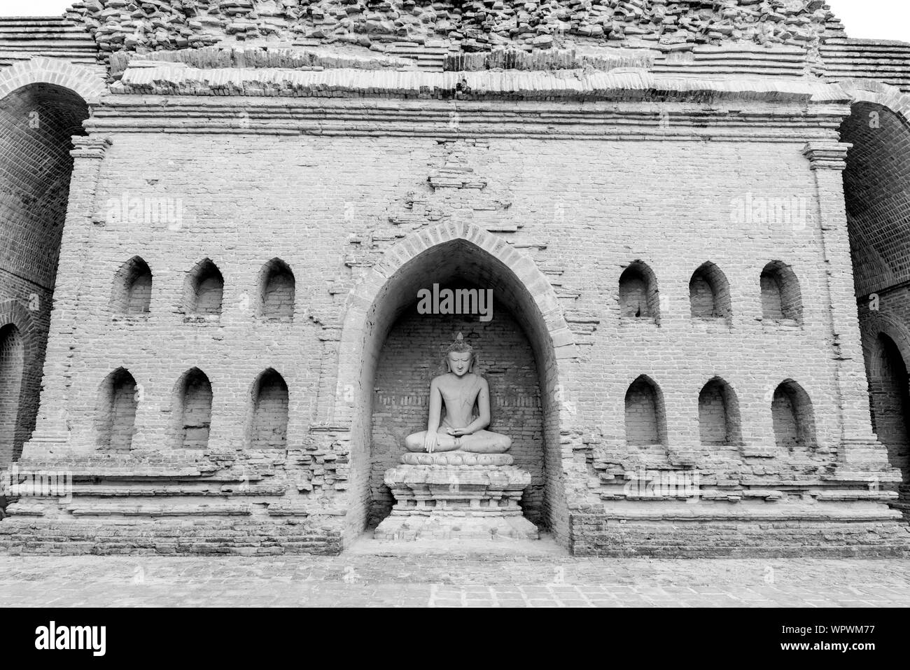 Immagine frontale di straordinaria statua del Buddha in rovina del tempio buddista a Bagan parco archeologico in Myanmar Foto Stock