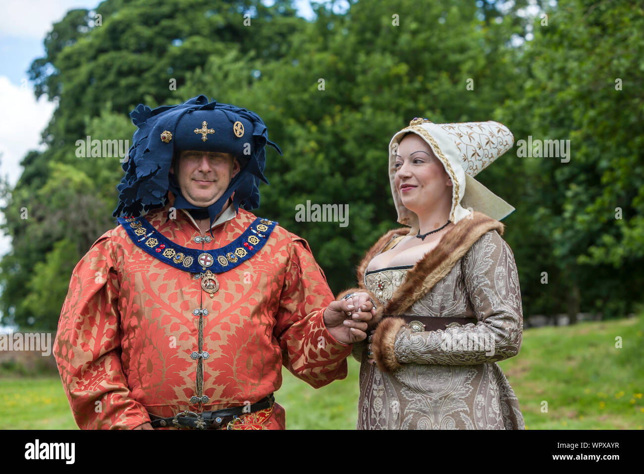 L uomo e la donna nel ricco costume medievale partecipanti al Medieval Fayre evento annuale in Tatton Park nel Cheshire, Inghilterra. Foto Stock