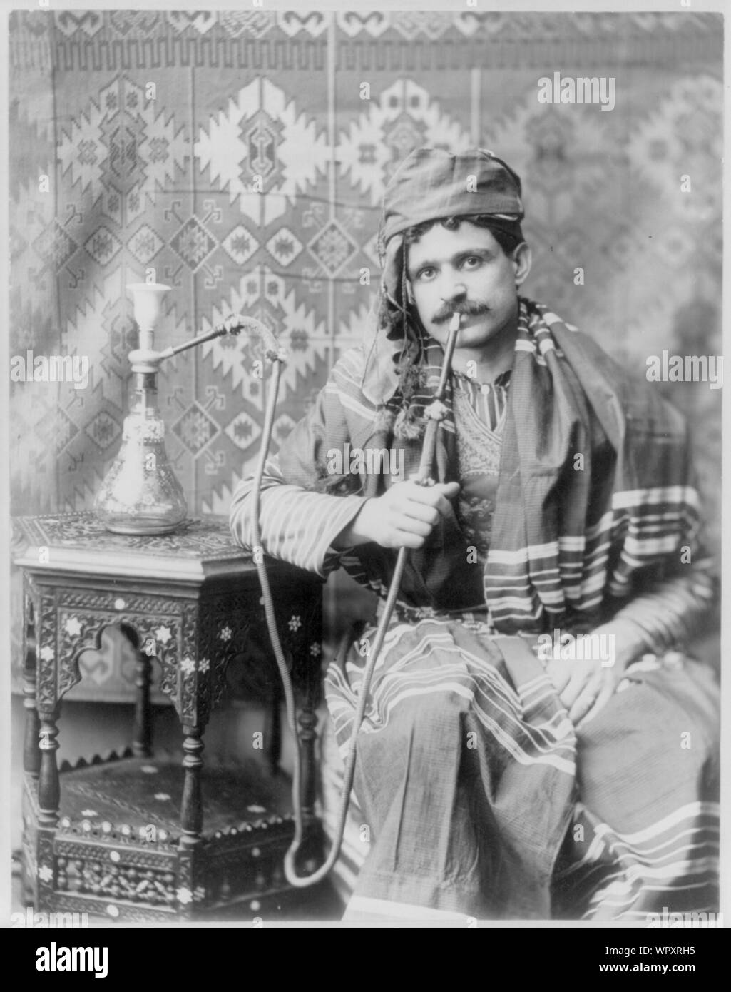 Uomo di fumare tubo acqua Foto Stock