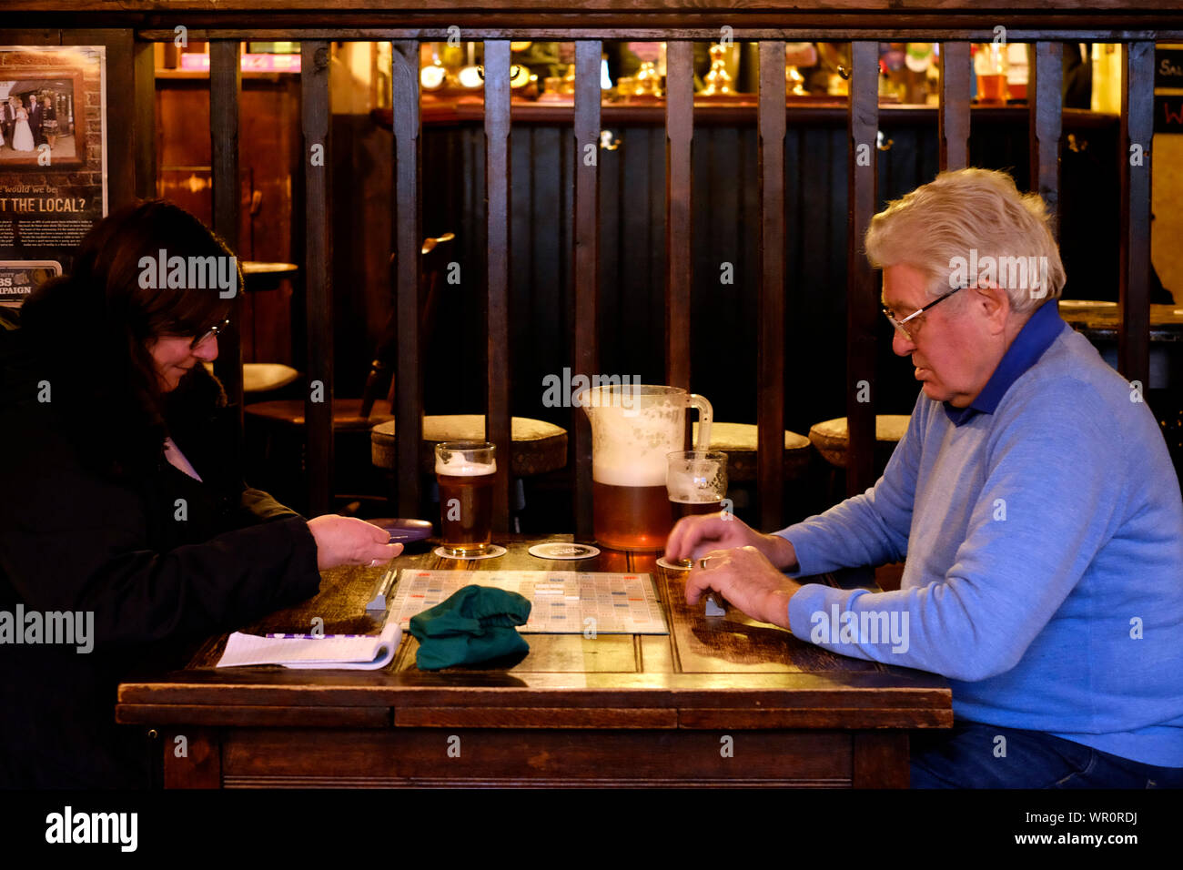 Coppia maschio e femmina giovane giocando scheda tradizionale gioco SCRABBLE in una real ale bar southsea England Regno Unito Foto Stock