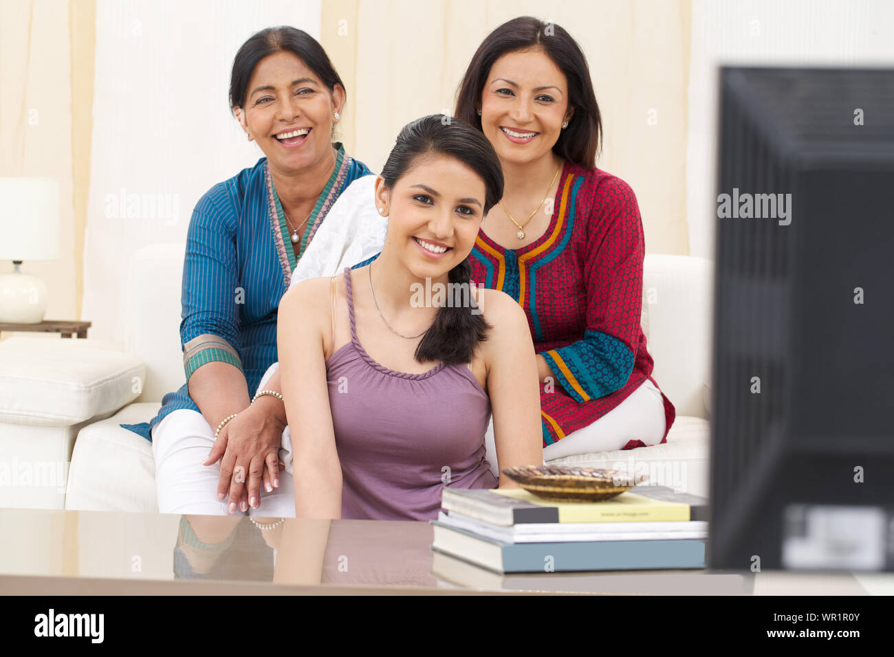 Famiglia di guardare la televisione e sorridente Foto Stock