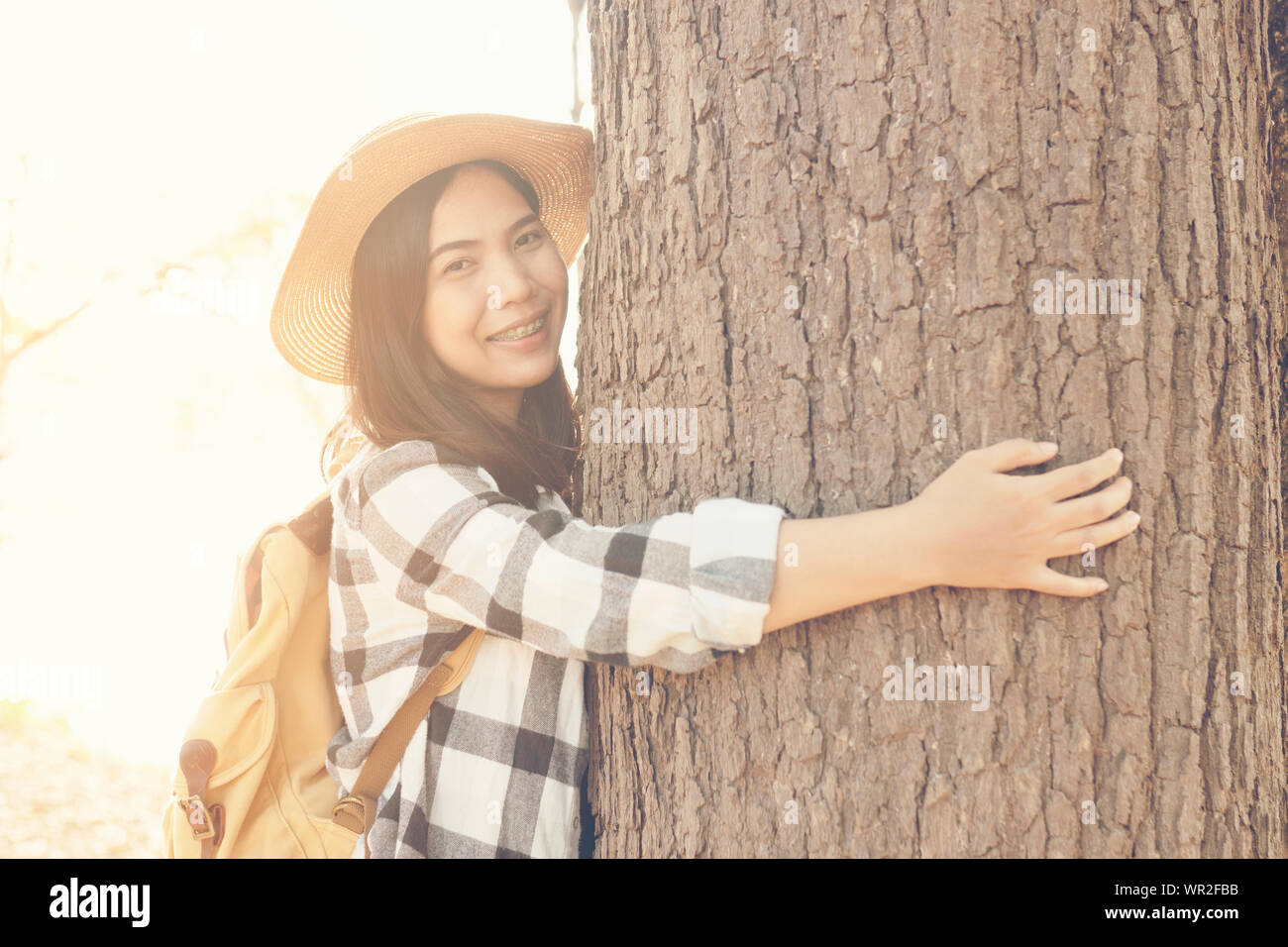 Donna asiatica abbraccio albero con amore Foto Stock