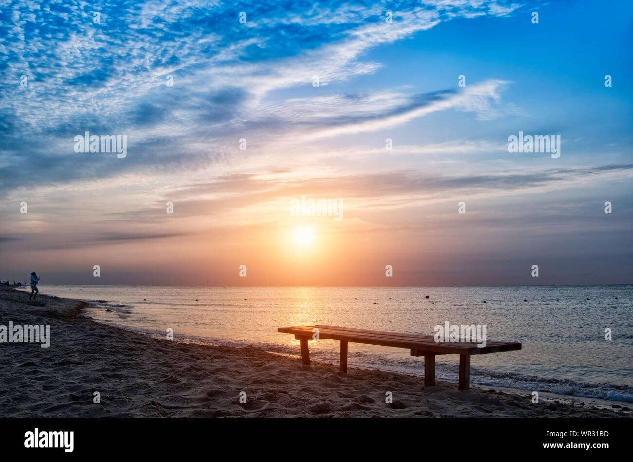 Tramonto luminoso con grande giallo sole sotto la superficie del mare Foto Stock