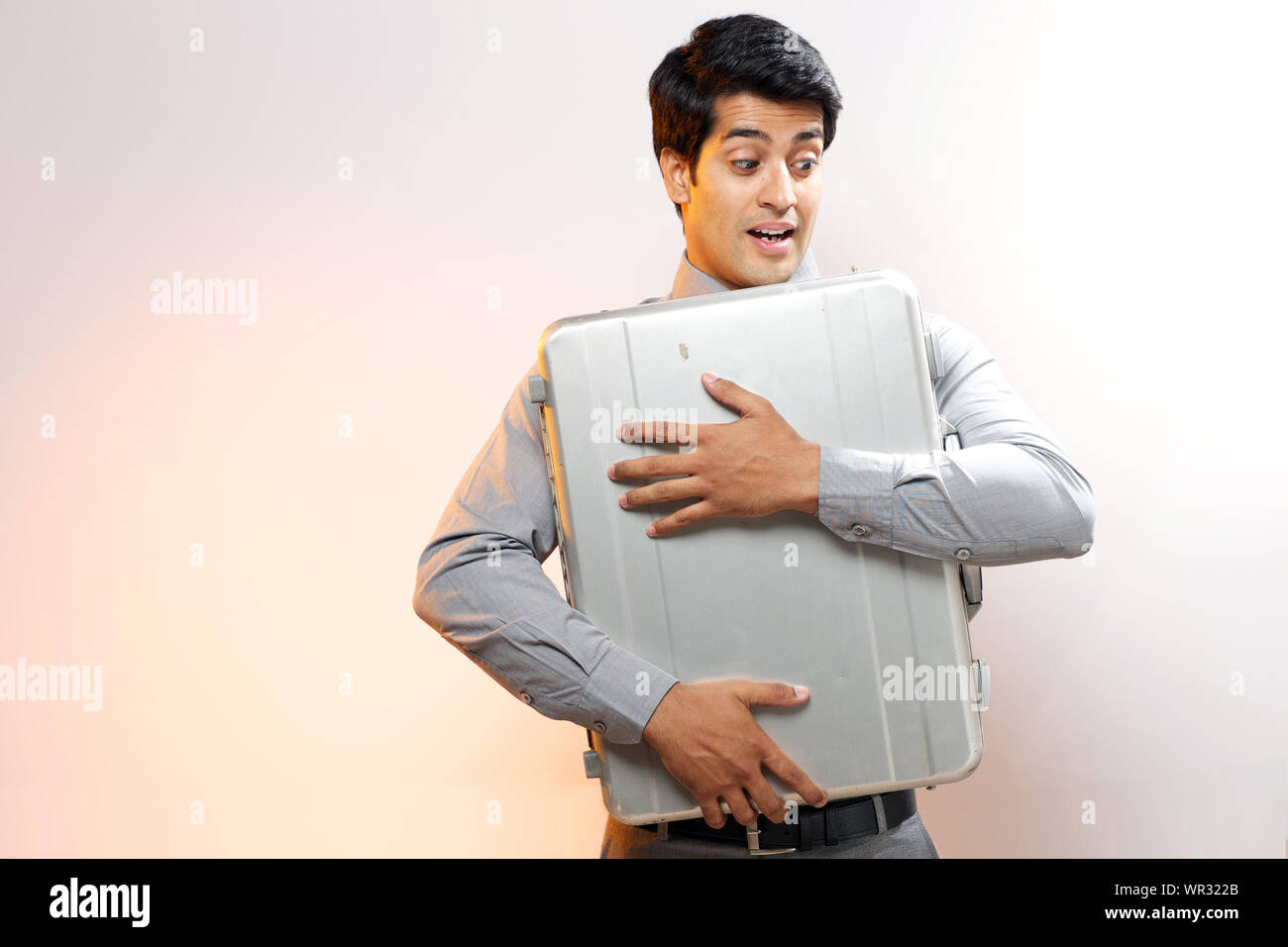 Imprenditore abbracciando una valigetta Foto Stock