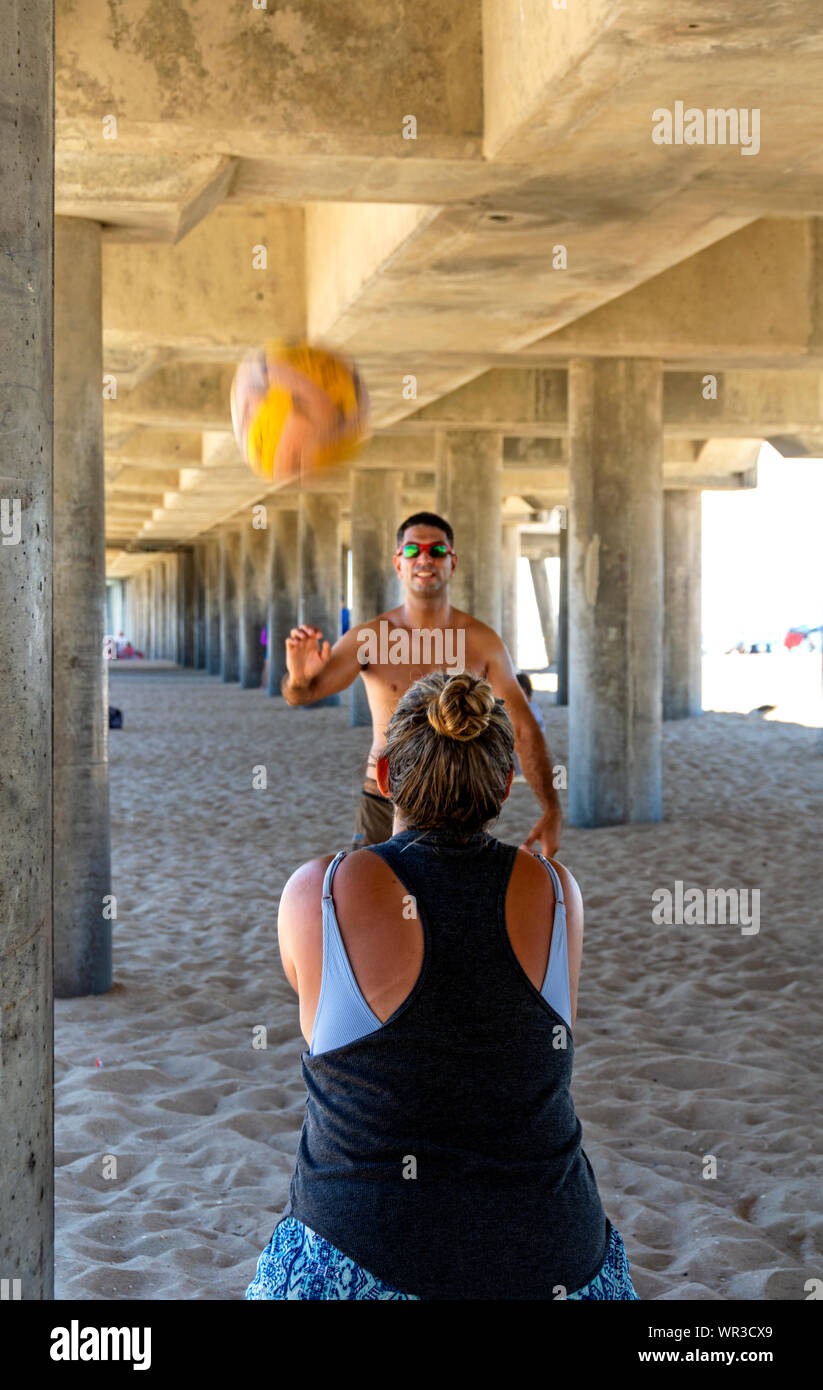 Huntington Beach, California / Stati Uniti d'America - Settembre 7, 2019: pallavolo pratica mentre cercano sollievo dal caldo pomeridiano sotto la Huntington Beach Pier. Foto Stock