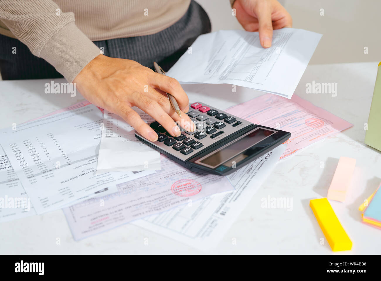 Man mano facendo finanze e calcolare sulla scrivania su costo presso l'ufficio domestico. Foto Stock