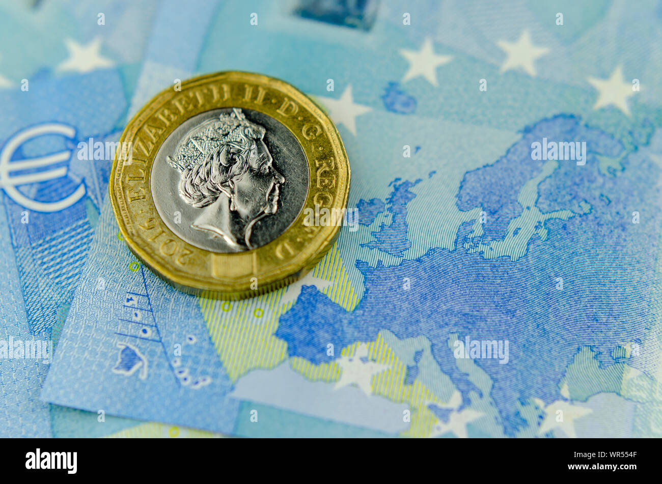 Una sterlina moneta sulla sommità di 20 Euro banconota accanto alla mappa dell'UE. Close up foto, appartamento vista laici.concetto per il cambio valuta, finanza e BREXIT Foto Stock