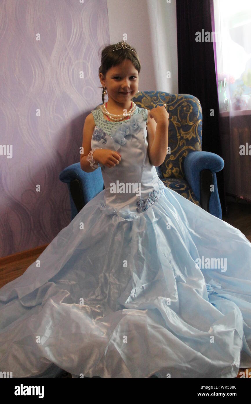 Felice giovane ragazza in vestito blu preparare per il compleanno festa in costume Foto Stock