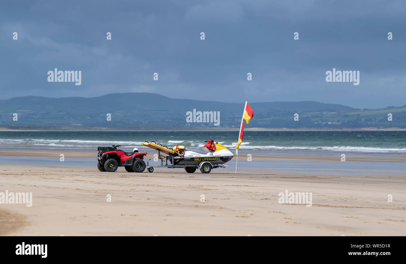 Bagnini RNLI moto quad e Jet Ski sulla spiaggia benone, Irlanda del Nord, Regno Unito. Foto Stock