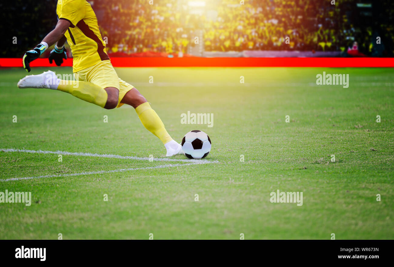 Il calcio o il giocatore di calcio in piedi con la palla sul campo per calciare il pallone da calcio a stadio di calcio Foto Stock