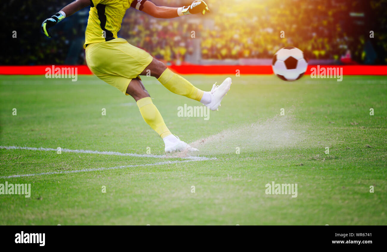 Il calcio o il giocatore di calcio in piedi con la palla sul campo per calciare il pallone da calcio a stadio di calcio Foto Stock