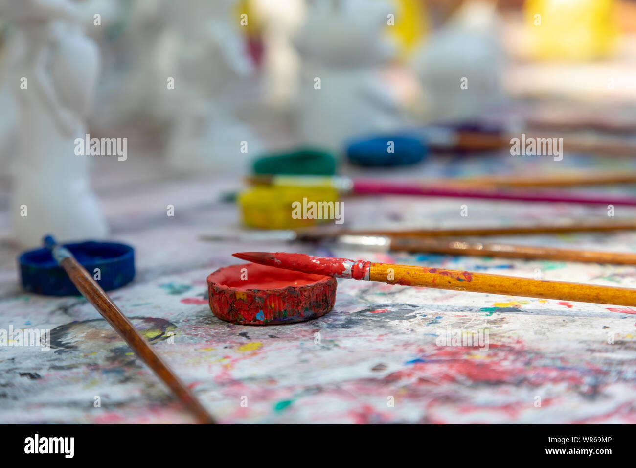 Pennelli e vernici colorate confuso il piano portapaziente Foto Stock