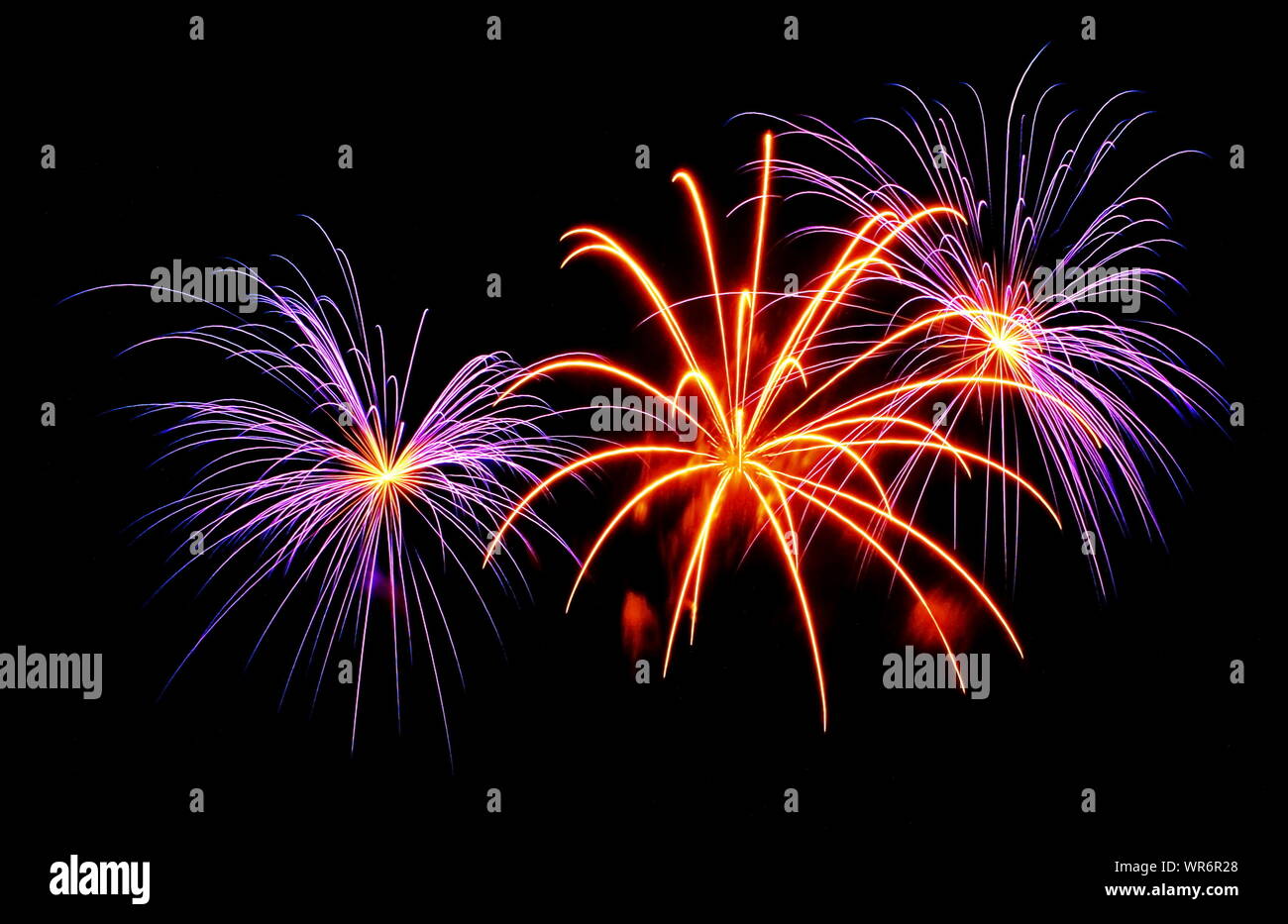 Le esplosioni e le pulegge scanalate colorata formando uno spettacolo di fuochi d'artificio scoppiettante. Foto Stock