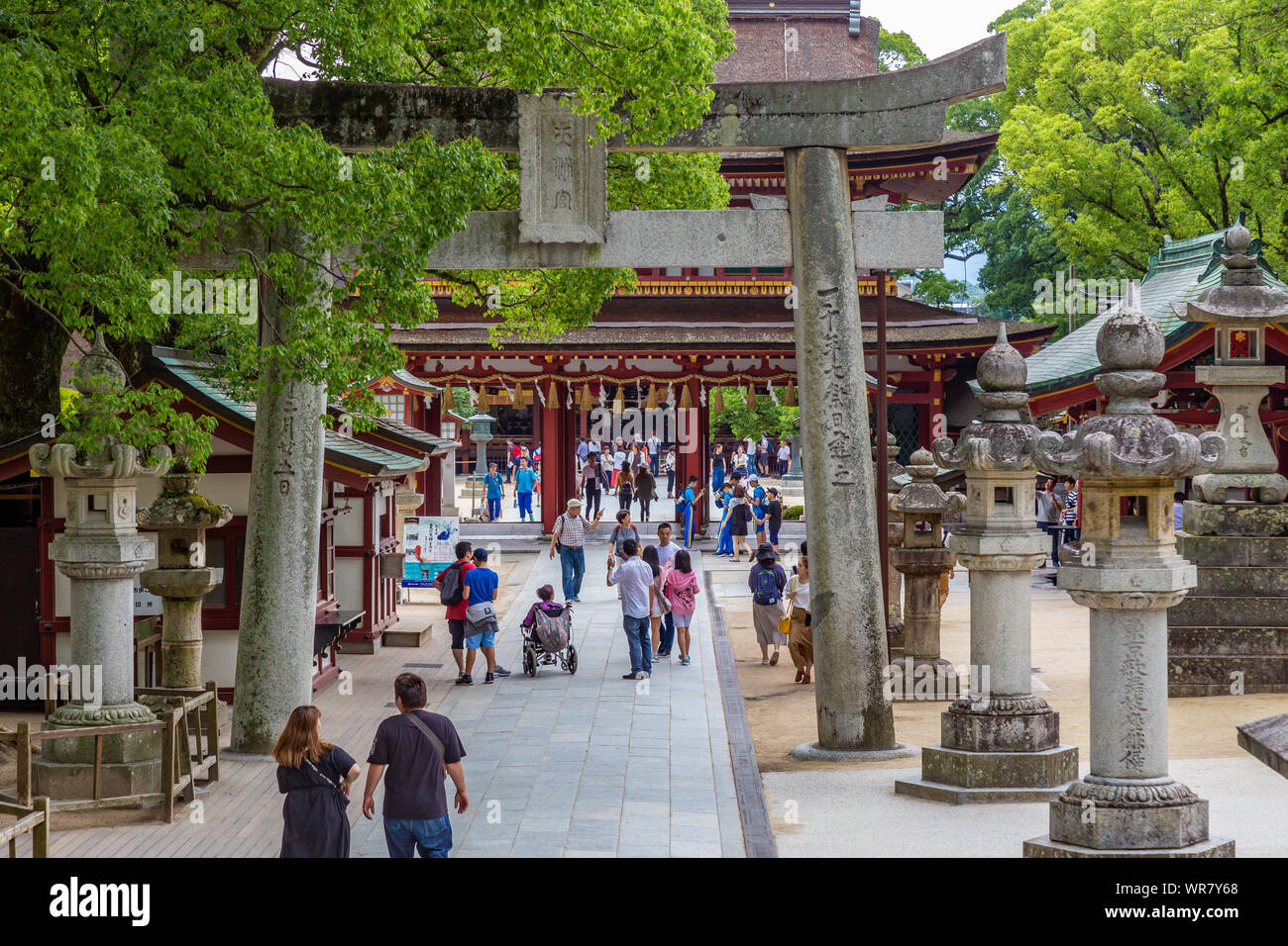 Dazaifu, Giappone - 10 Luglio 2019 - i turisti e locali popolo giapponese a piedi in e fuori attraverso l'entrata che conduce al famoso Santuario Tenmangu in Daza Foto Stock