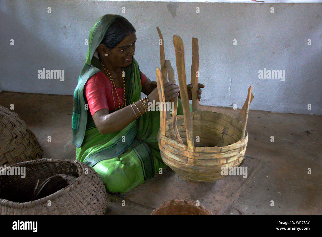 Idolo di donna impegnata nella realizzazione di paniere dalle cinghie di bamboo a Janapada Loka Folk Art Museum vicino Ramanagara, Karnataka, India, Asia Foto Stock