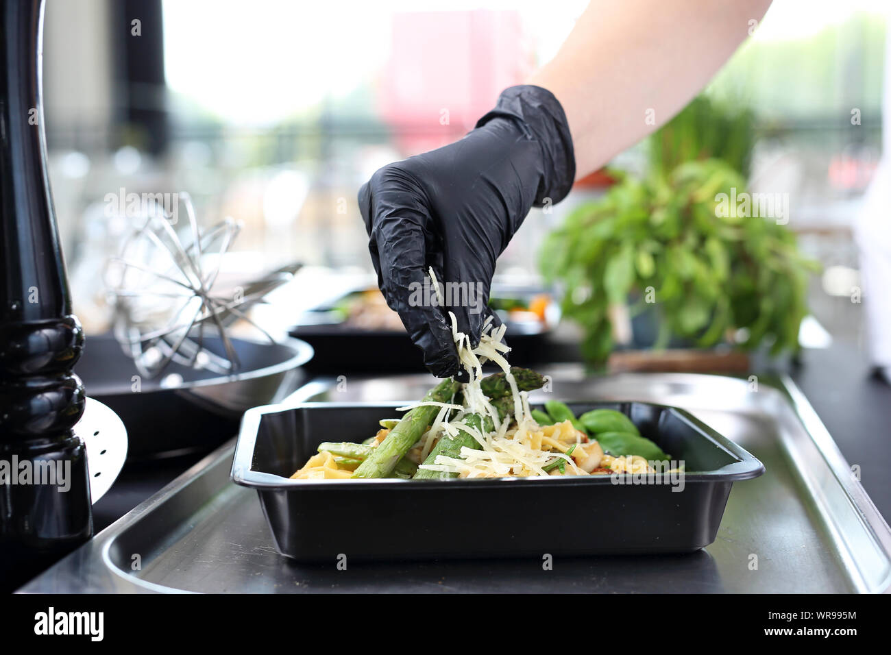 Il cuoco prepara il cibo. Pasta con gli asparagi. Take-out piatto Foto Stock