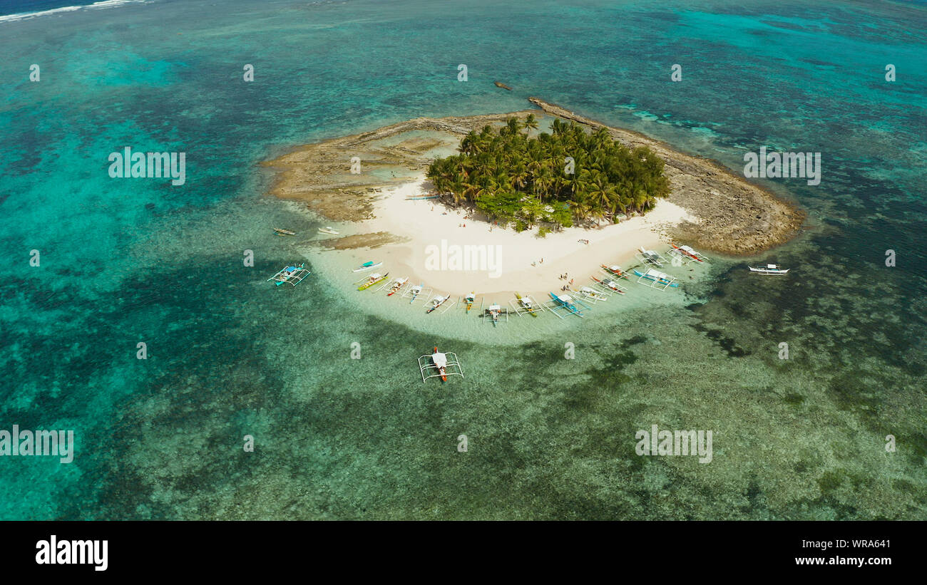 Isola tropicale con palme, spiaggia con turisti e barche. Isola Guyam, Filippine, Siargao. Estate viaggi e concetto di vacanza Foto Stock