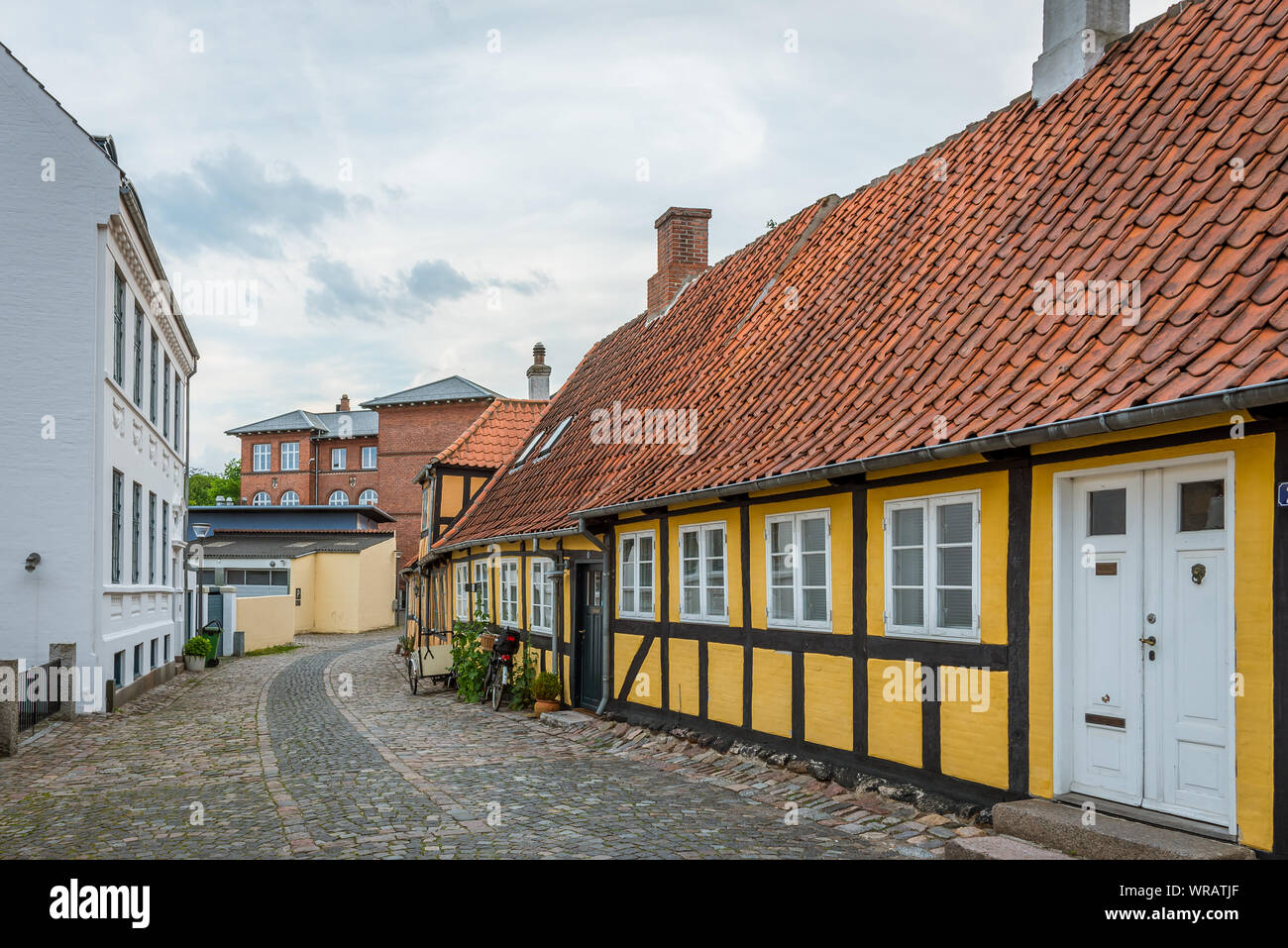 Una metà- legno casa gialla su una mattonella-pietra-street nella città vecchia di Svendborg, Danimarca, luglio 10, 2019 Foto Stock
