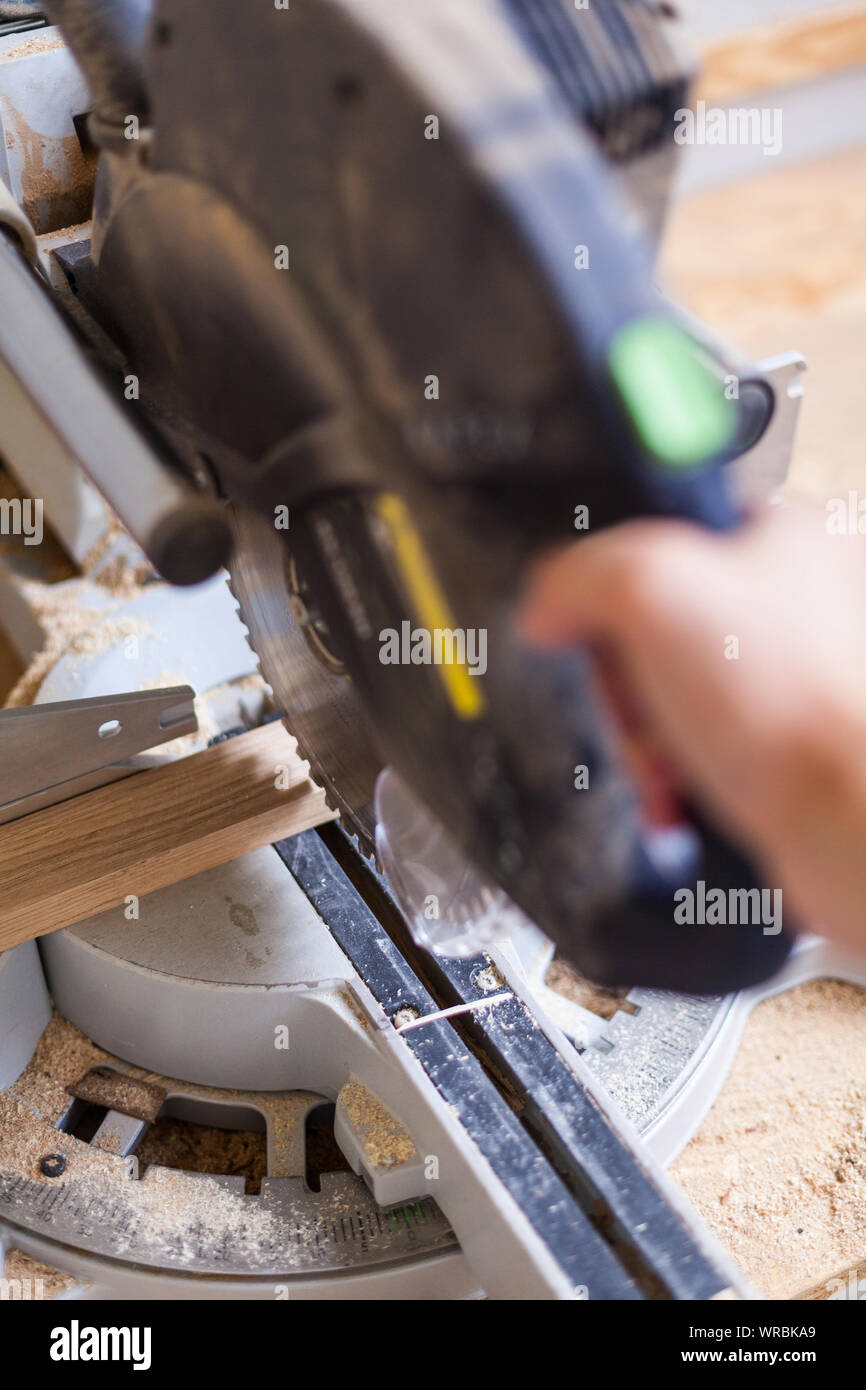 Troncatrice per legno a taglio con sega con lama per sega tagliare un pezzo di legno in legno workshop, abbreviare Foto Stock