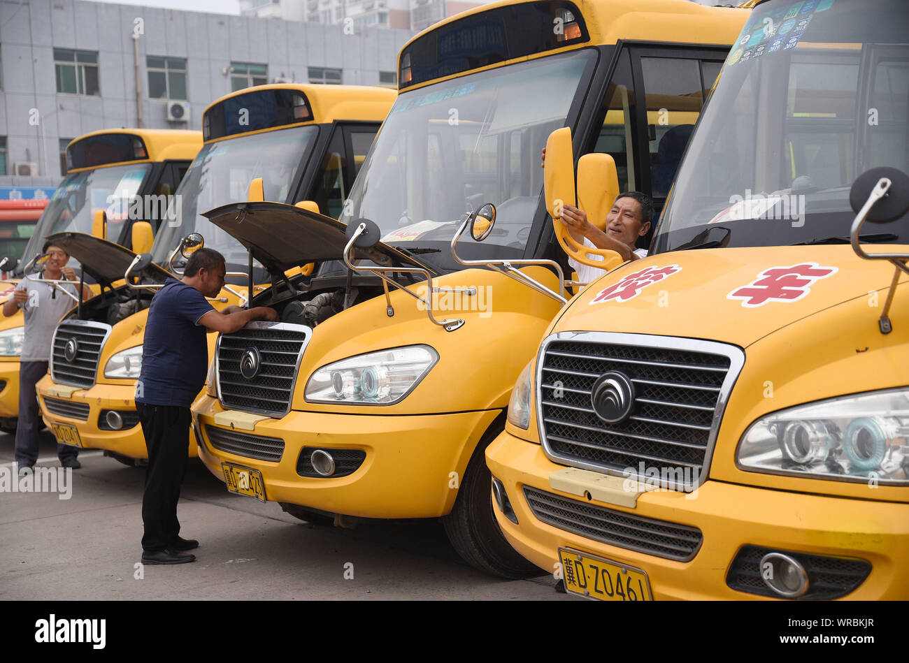 Tecnici cinesi esaminare schoolbuses durante una sessione di checkup in preparazione per la upocming nuova scuola semestre Cixian County, Handan Città, n. Foto Stock