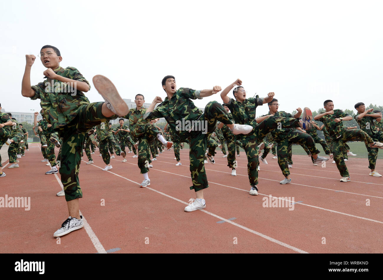 Matricole cinesi studenti esercizio durante un addestramento militare prima sessione il nuovo semestre inizia al primo Cixian Senior High School a Cixian Coun Foto Stock