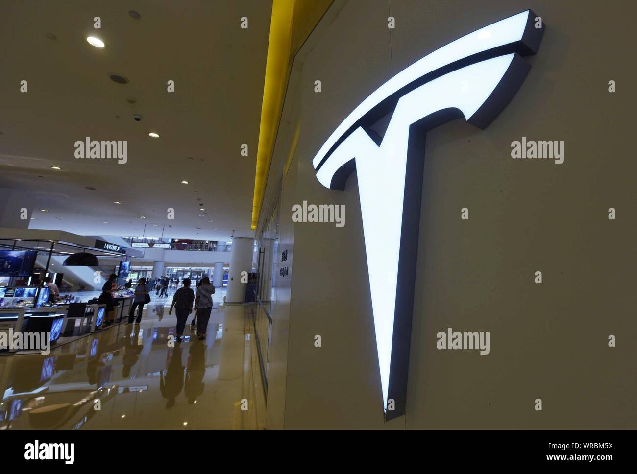 * * * * FILE acquirenti cinesi a piedi passato una Tesla store presso un centro commerciale per lo shopping nella città di Hangzhou, a est della Cina di Provincia dello Zhejiang il 14 maggio, 2019. Noi electric Foto Stock