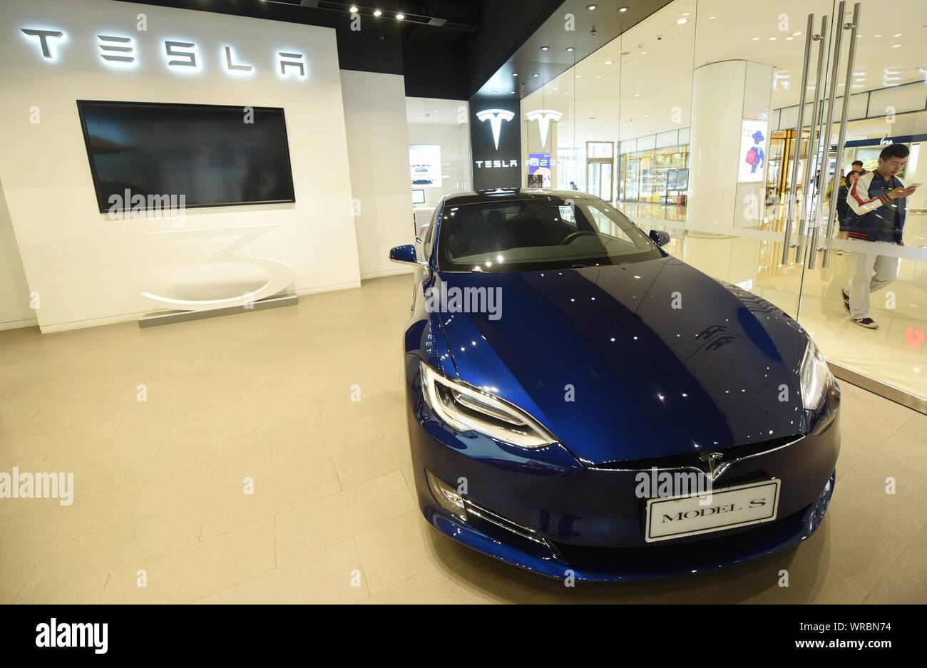 * * * * FILE acquirenti cinesi a piedi passato una Tesla store presso un centro commerciale per lo shopping nella città di Hangzhou, a est della Cina di Provincia dello Zhejiang il 14 maggio, 2019. Noi electric Foto Stock