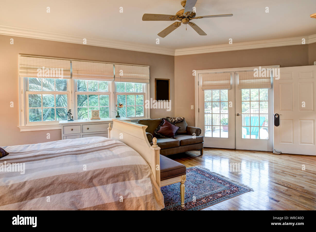 La camera da letto di gusto interno con pavimenti in legno e porte francesi Foto Stock