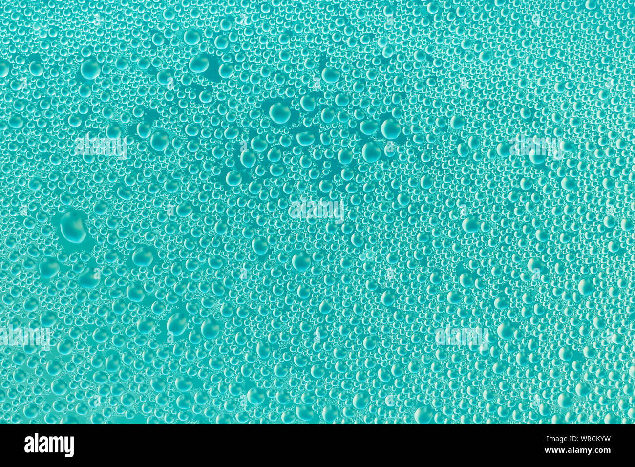 Gocce d'acqua sulla superficie di turchese. Il blu e il verde dello sfondo astratto di bolle di sapone. Acquamarina texture di vetro lucido. Schema di gocce. Co trasparente Foto Stock