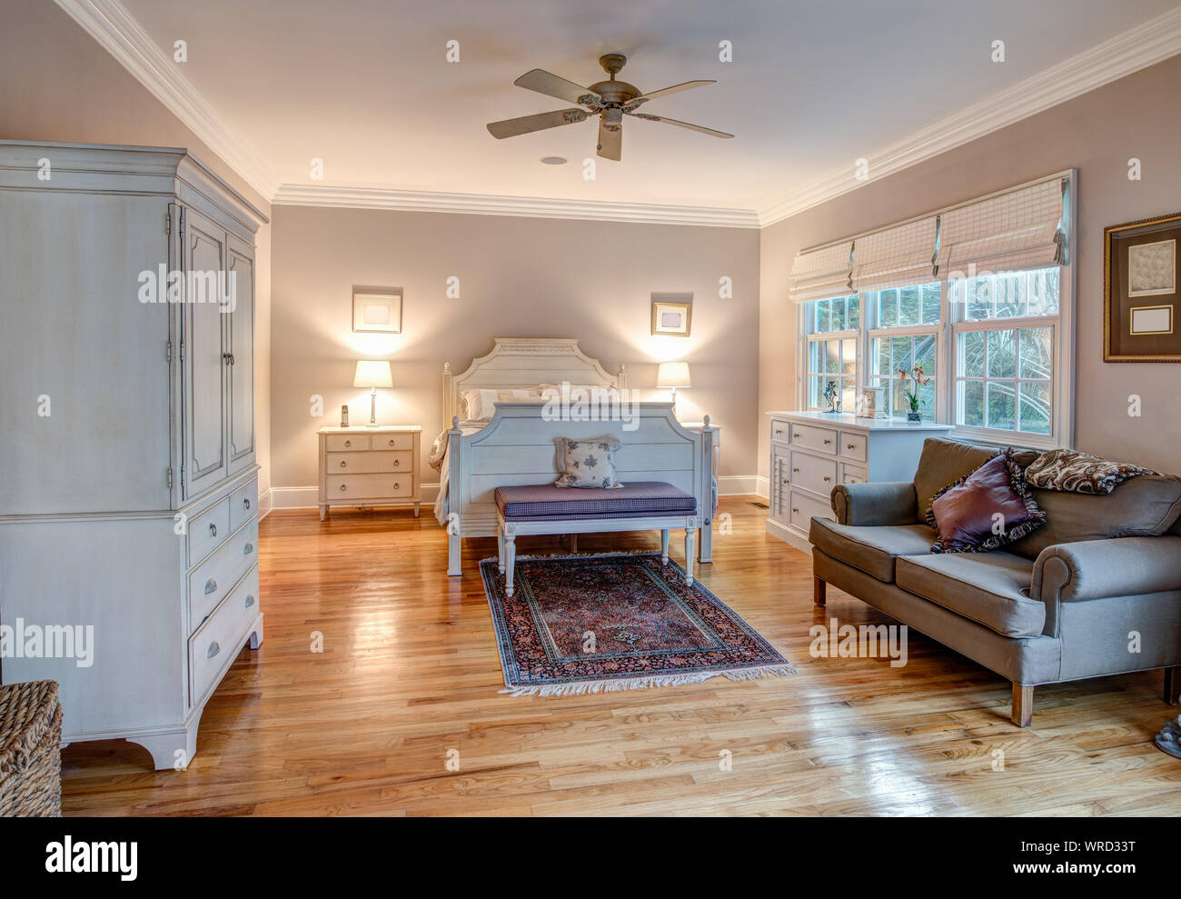 Camera elegante con pavimenti in legno duro e arredi di gusto Foto Stock