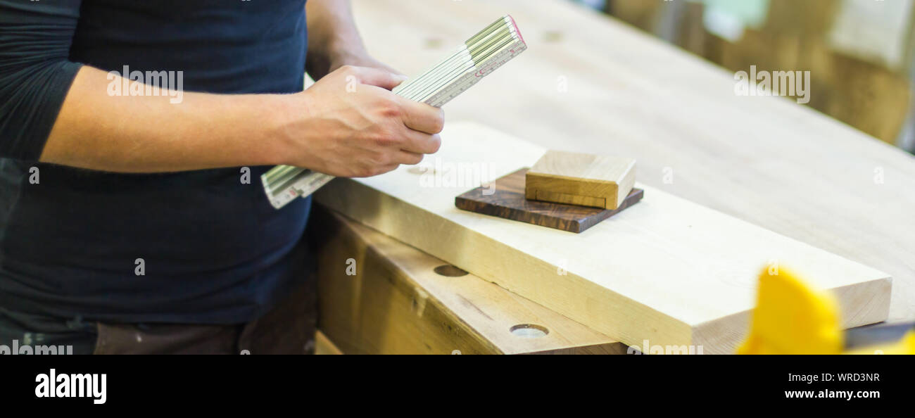 Femmina falegname falegname utilizzando la scala misuratore regola personale e campioni di legno di campioni di materiale in officina Foto Stock