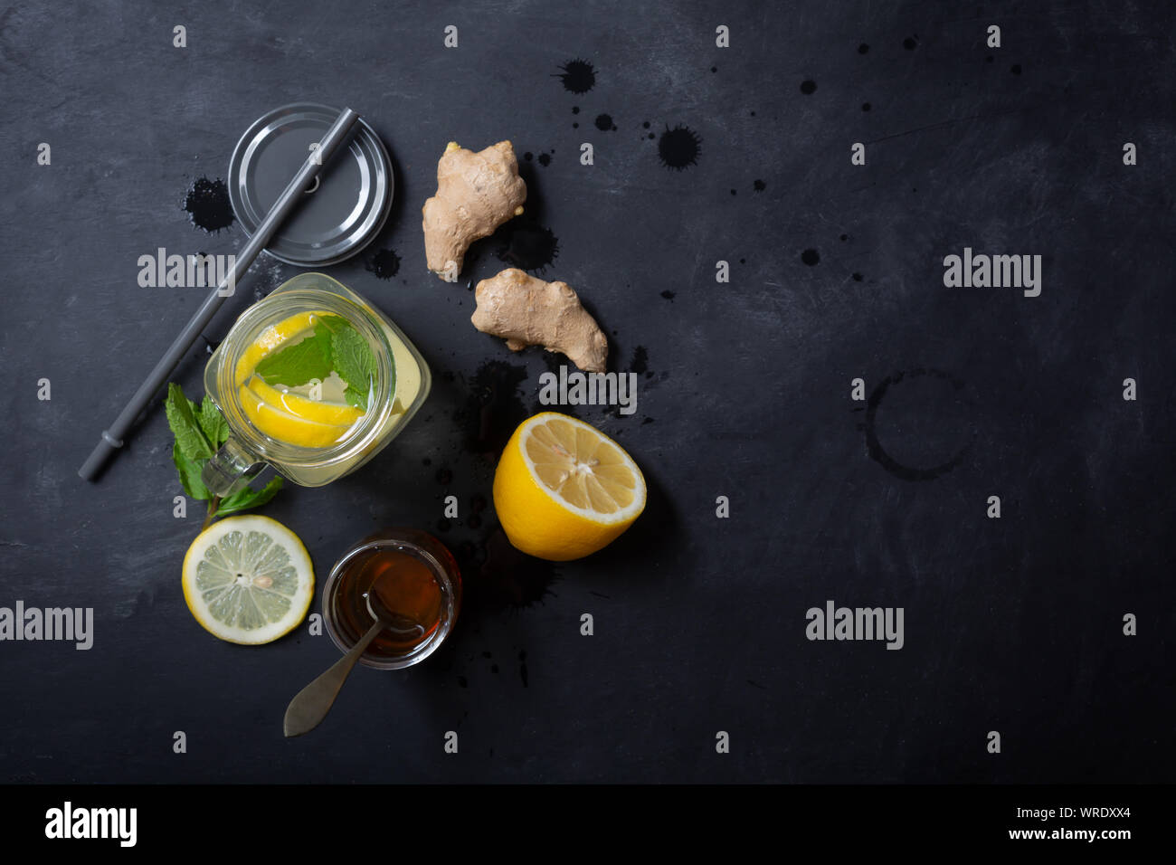 Lo zenzero acqua in un barattolo di vetro con limone e miele su uno sfondo nero con spazio di copia Foto Stock