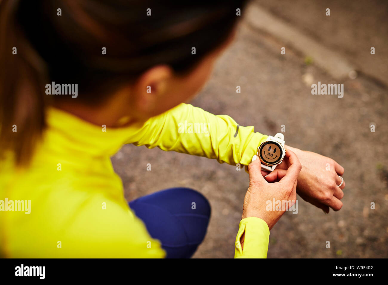 Una femmina di runner la sua impostazione orologio fitness. Foto Stock