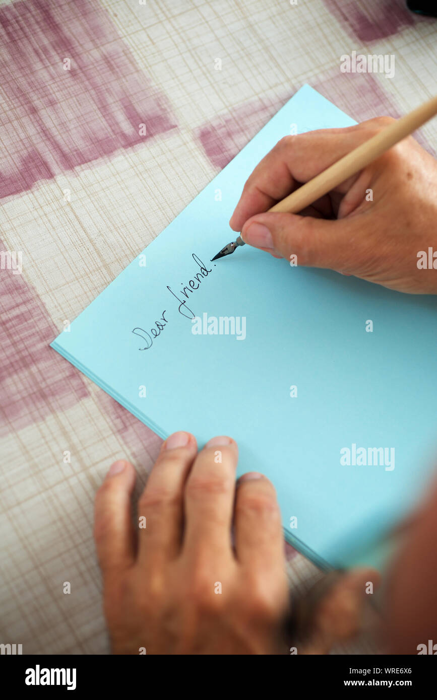 Uomo senior di scrivere una lettera ad un amico. Foto Stock