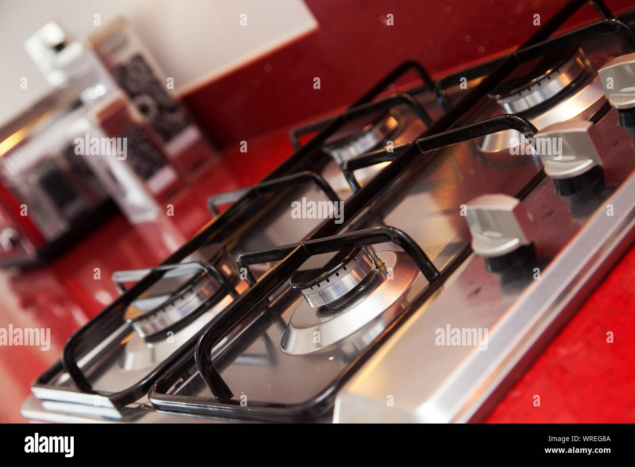 Un piano cottura a gas in una cucina moderna con colore rosso brillante piano di lavoro. Foto Stock