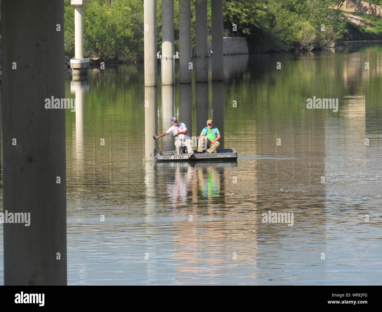 Due uomini con attività di pesca in una piccola barca nel fiume Concho in San Angelo, Texas, Stati Uniti d'America Foto Stock