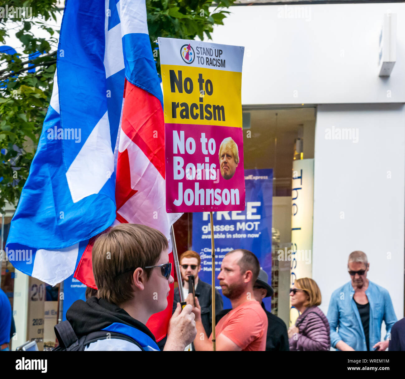 Tutti sotto uno striscione indipendenza (AUOB) rally, Perth, Scotland, Regno Unito. Indipendenza sostenitore detiene il cartello con Boris Johnson no al razzismo Foto Stock