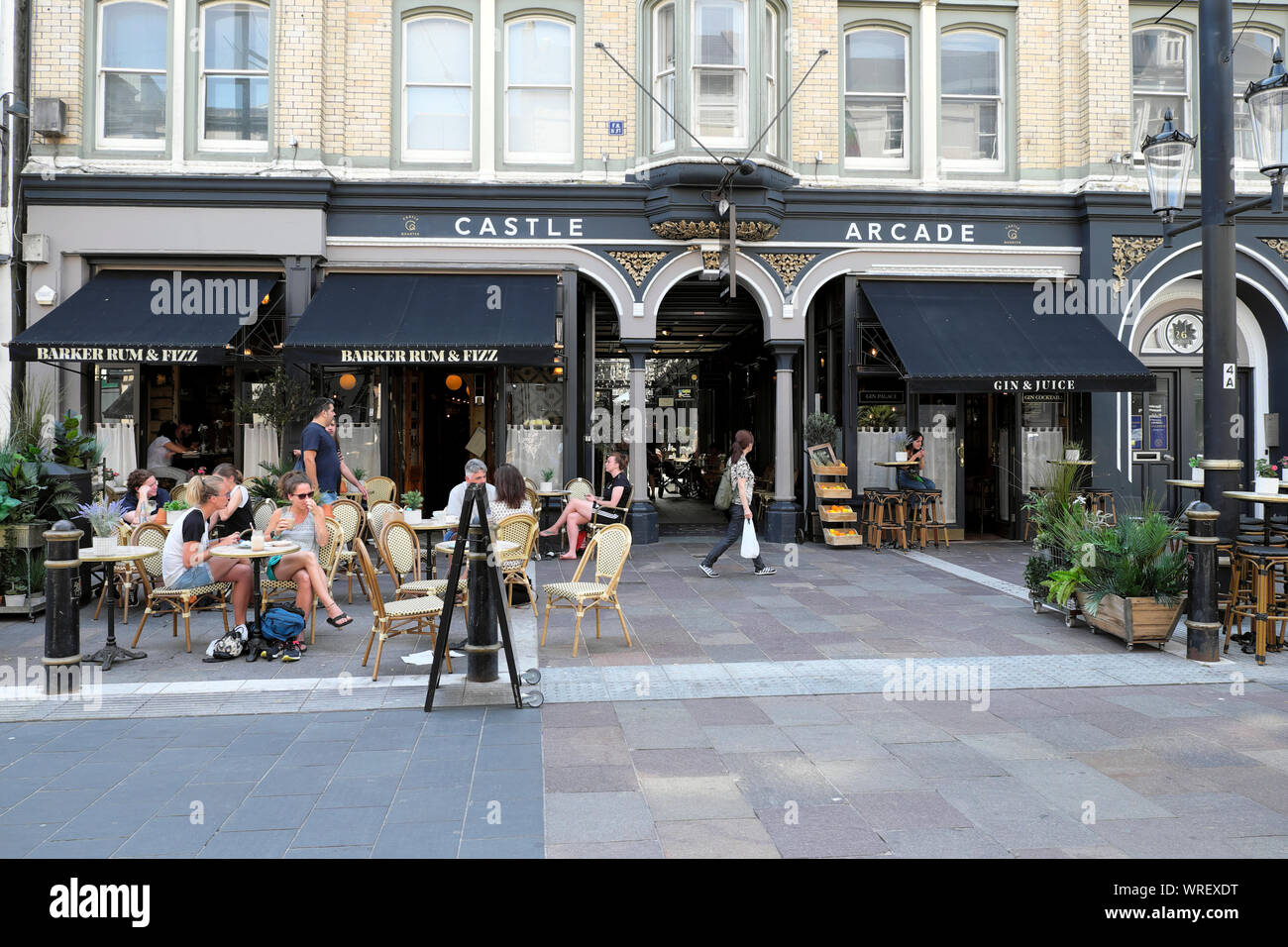 Le persone sedute a tavoli fuori Barker Rum & Fizz bar ristorante Castello Arcade il St Mary Street in summerCardiff City Centre Wales UK KATHY DEWITT Foto Stock