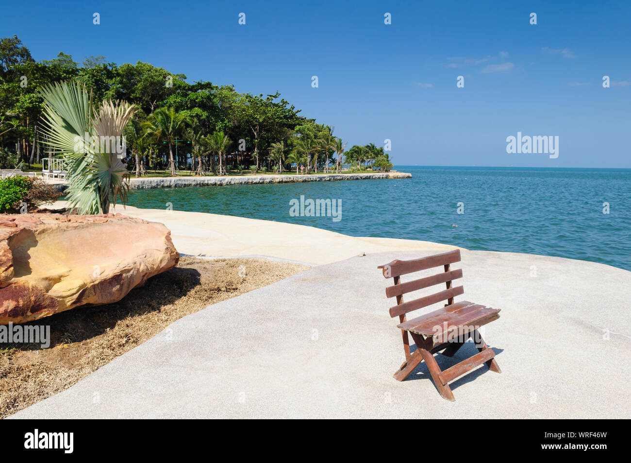 Panca in legno bella vista sul mare calmo. Ambiente verde paesaggio, posto rilassante con un banco di lavoro su una spiaggia di Pattaya, Thailandia Foto Stock