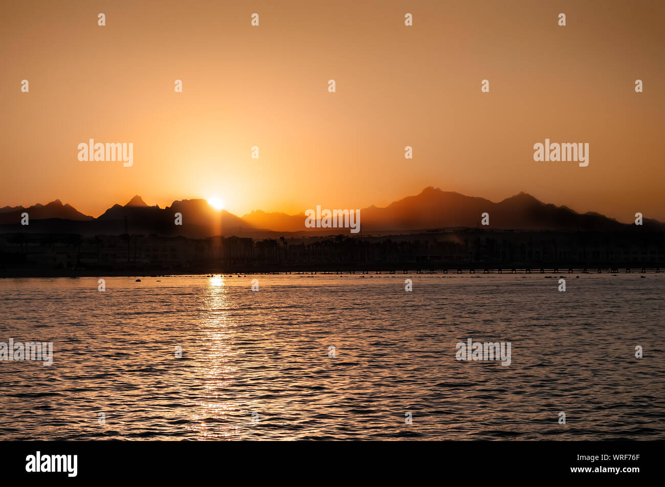 Bel tramonto paesaggio al Mar Nero e montagna sopra cielo arancione con la riflessione di Sun Foto Stock