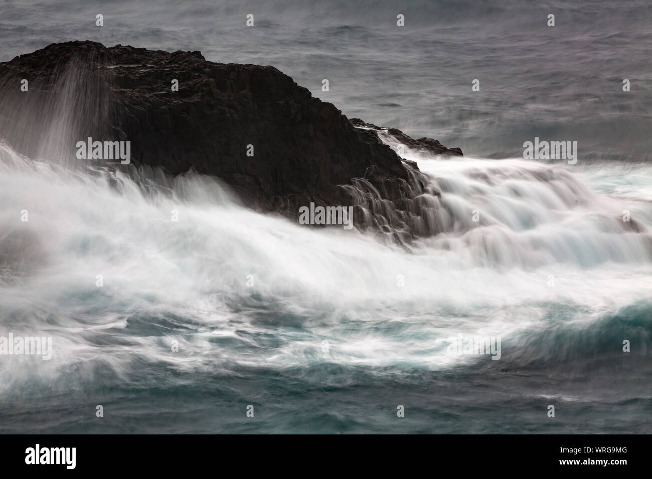 Una lunga esposizione della vista di dettaglio degli alti spruzzi delle onde di colpire le rocce a Playa de Nogales in La Palma, Spagna. Foto Stock
