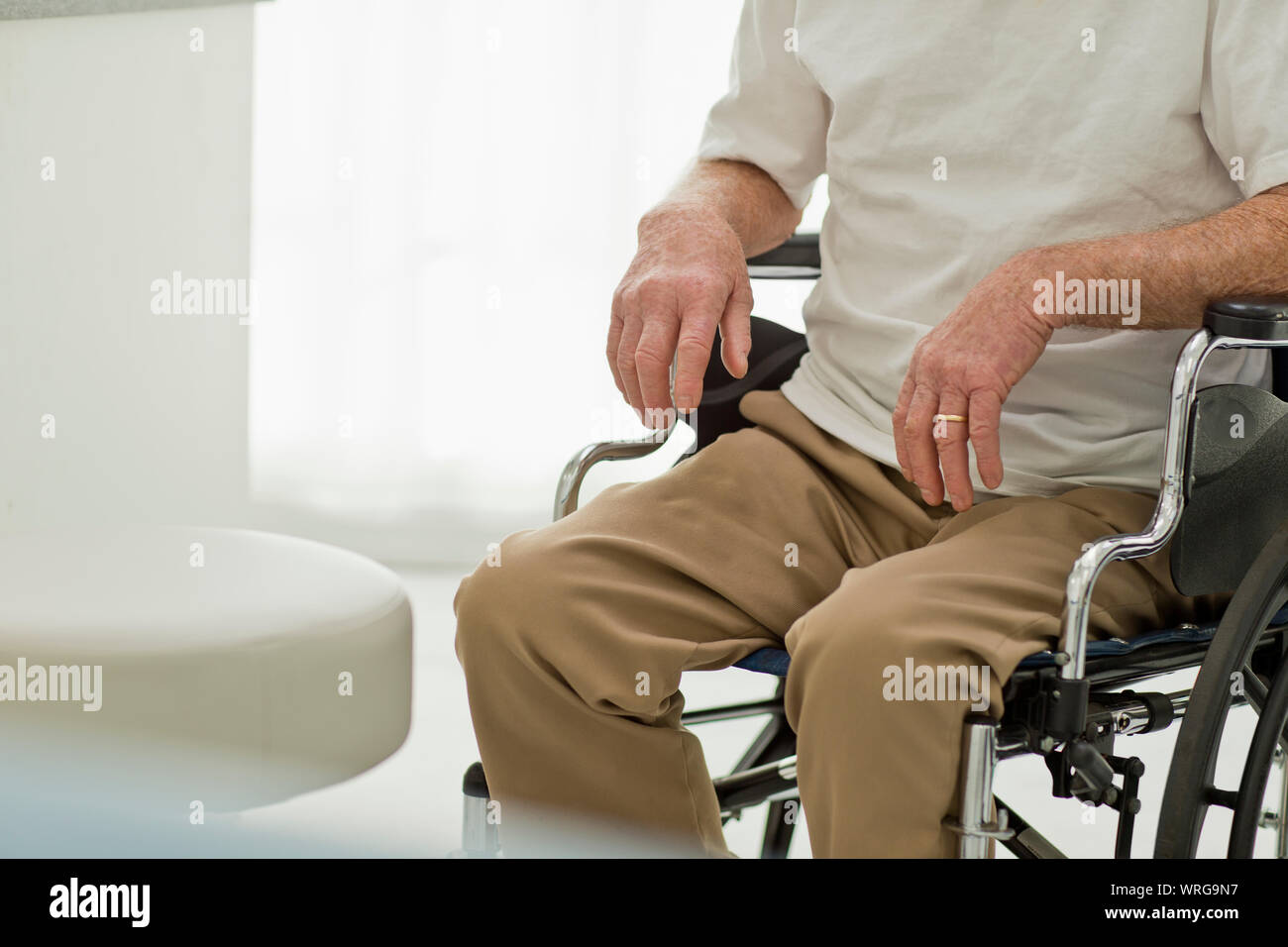 Senior uomo seduto in una sedia a rotelle. Foto Stock
