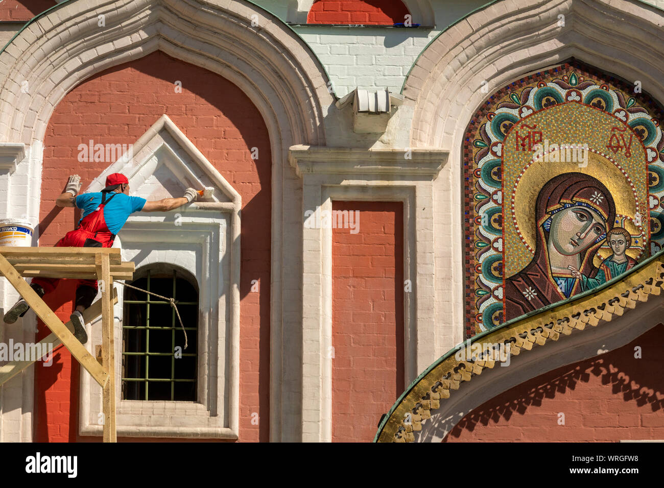 Un uomo dipinge la facciata della Cattedrale dell icona della Madre di Dio di Kazan sulla Piazza Rossa di Mosca, Russia Foto Stock