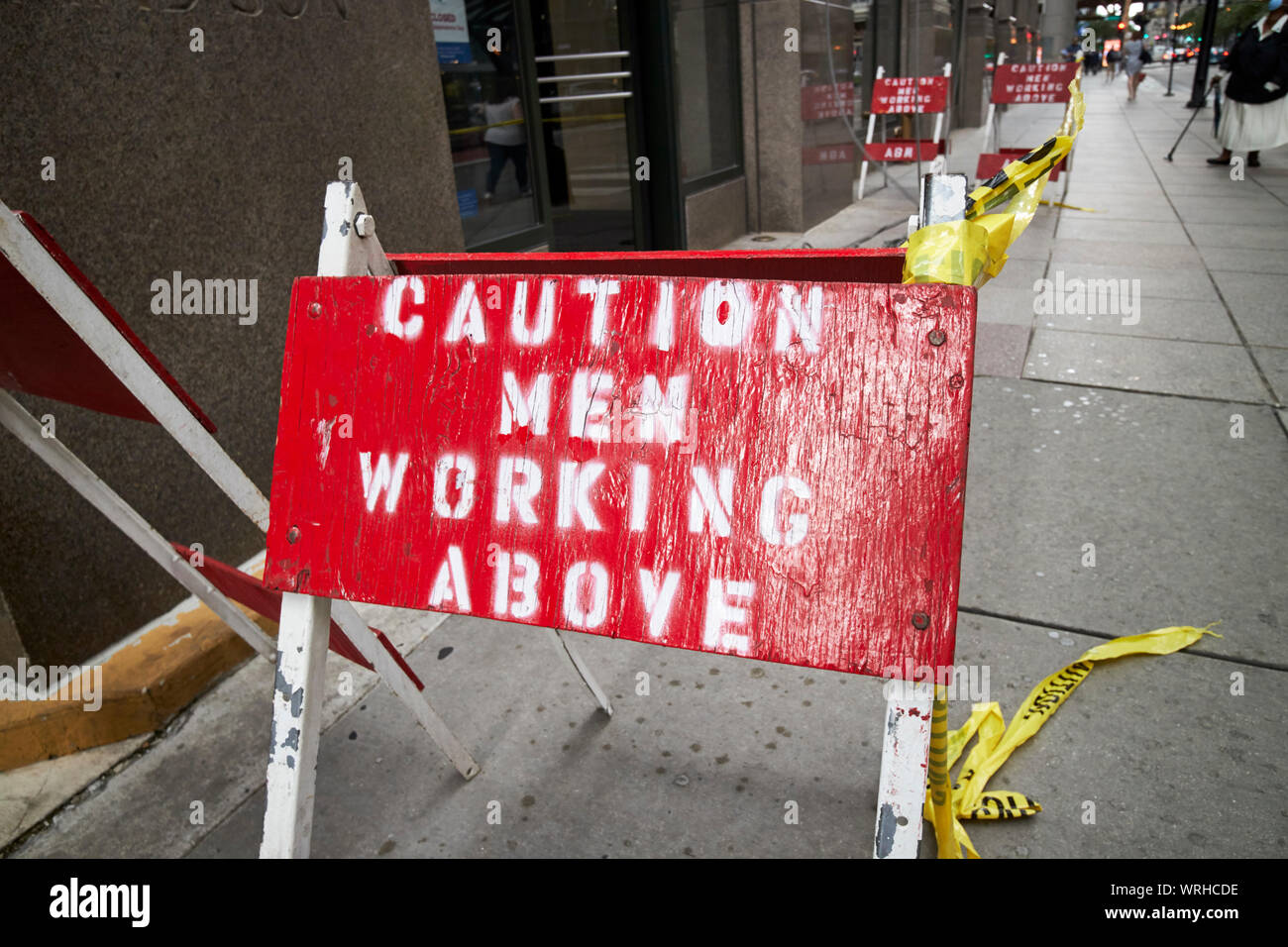 Attenzione uomini al lavoro sopra i segni sul marciapiede sotto alto edificio Chicago Illinois USA Foto Stock