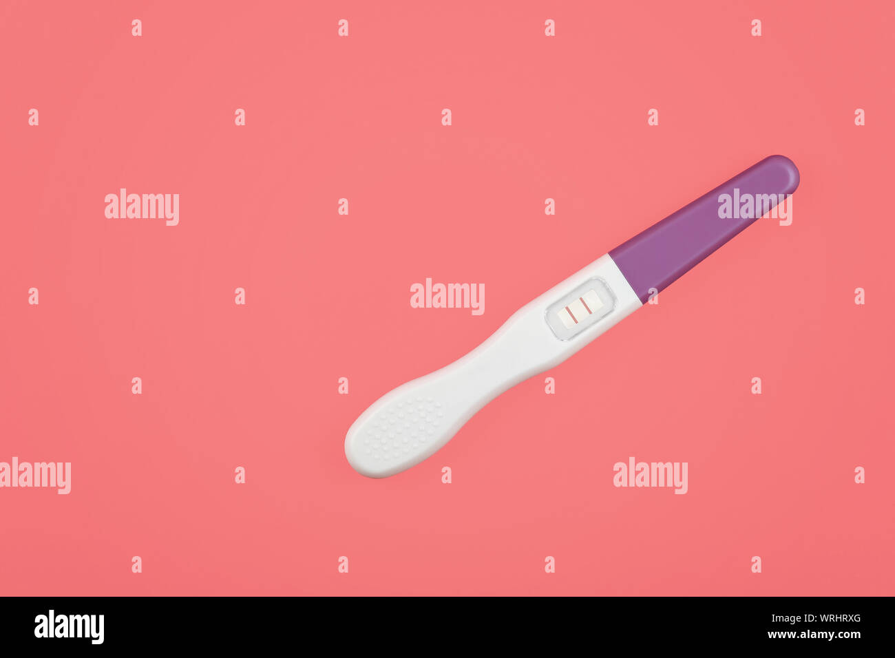 Chiudere uno positivo (gravidanza) Risultato test di gravidanza pastello su carta rosa, sfondo elevato angolo di alta vista, direttamente al di sopra di Foto Stock