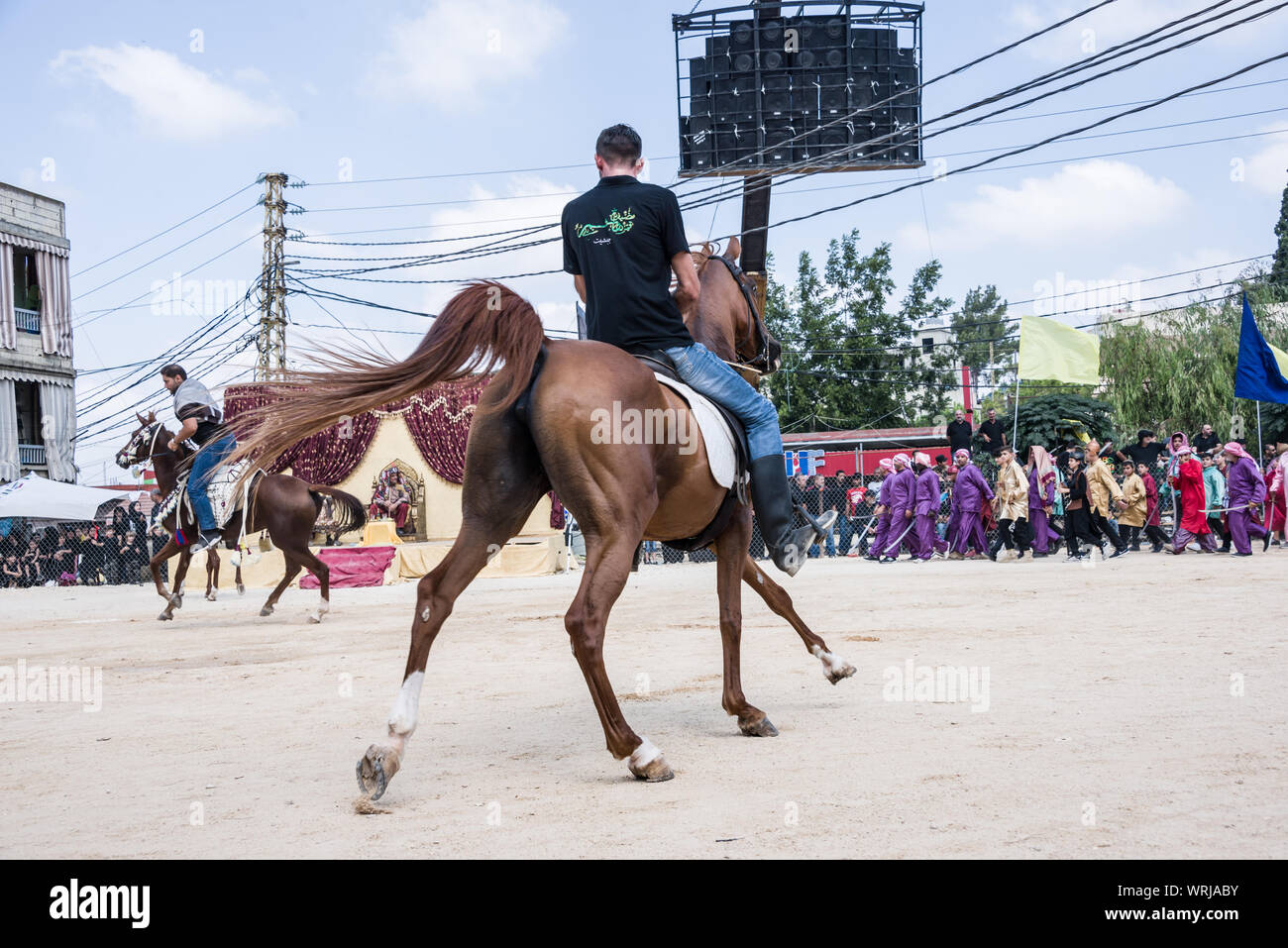 Persone in Jibchit, Nabatiyeh comune, Libano, in lutto per la morte di imam Hussein, nipote del Profeta Maometto, attraverso una rievocazione storica della sua morte durante la battaglia di Karbala in 680annuncio. Un cast di 100 ha preso parte, completa con i cavalli e un cammello. Il Libano, 10 Settembre 2019 Foto Stock