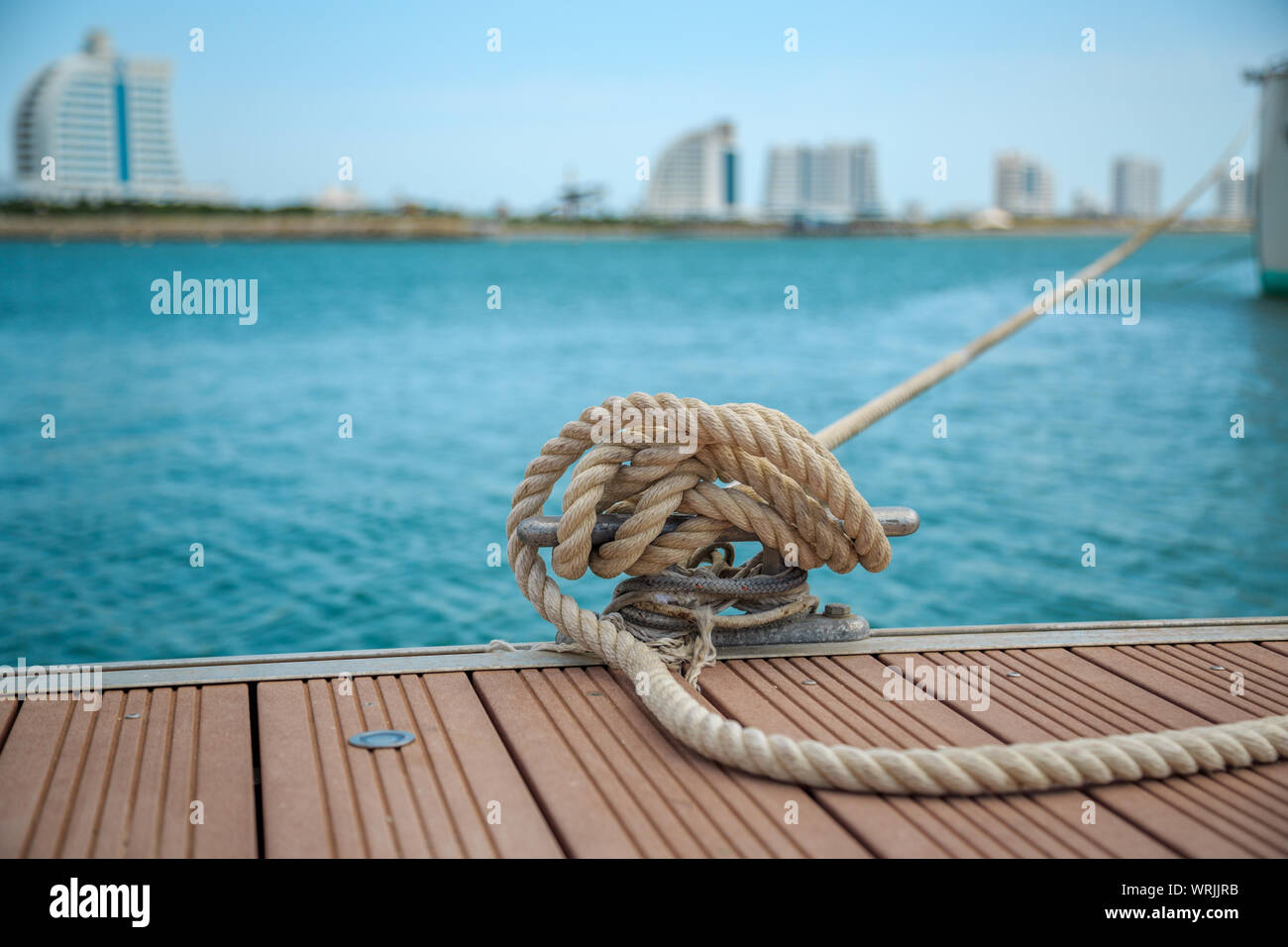 Ormeggio yacht corda con una estremità annodata legato attorno un gancio su un molo in legno Foto Stock