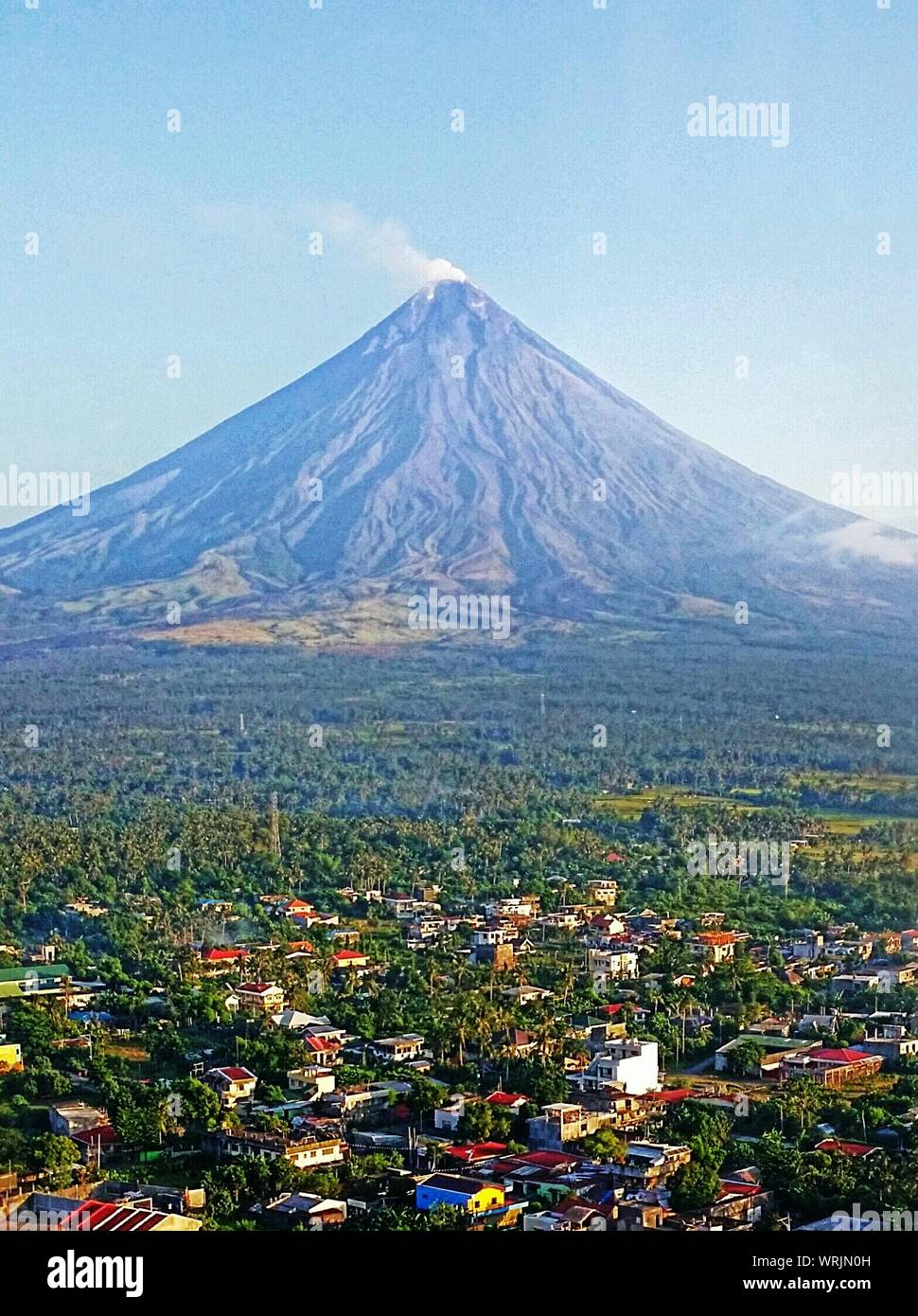 Vista panoramica del paesaggio verde e Vulcano Mayon contro Sky Foto Stock