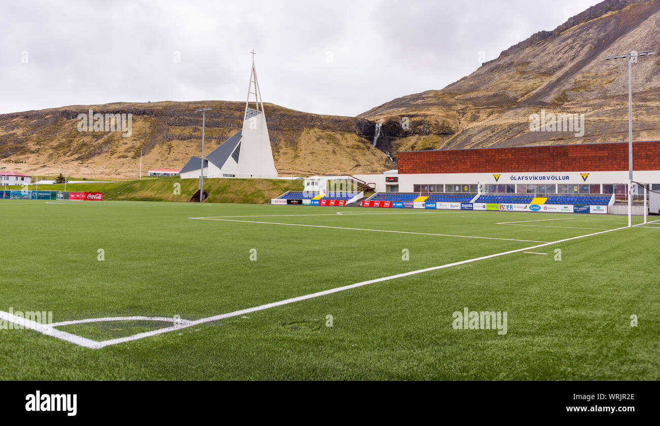 OLAFSVIK, SNAEFELLSNES PENINSULA, Islanda - Campo di calcio e la chiesa, nella piccola cittadina sulla costa. Foto Stock